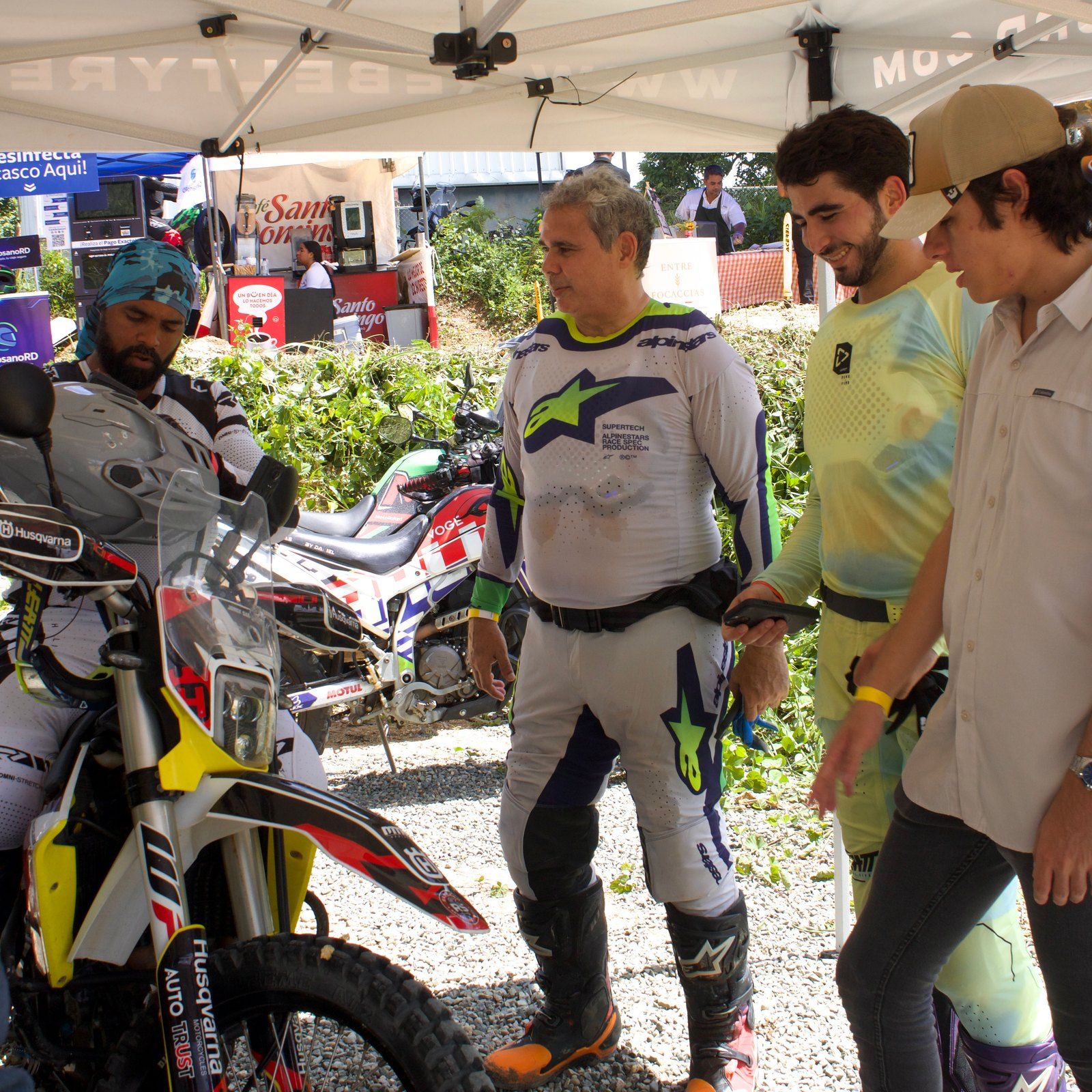 Pilotos y representantes de marcas conversando en una carpa del evento